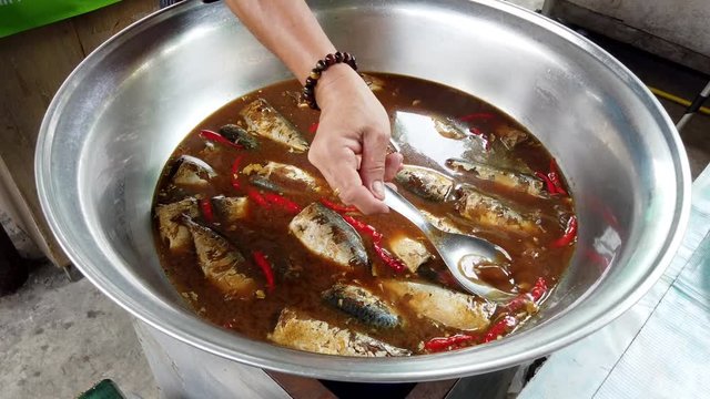 Sardines Cook in a Broth on a Grill at Market.