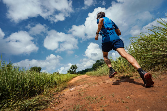 Shoes From Behind Men He Is Running A Trail. In The Natural Path