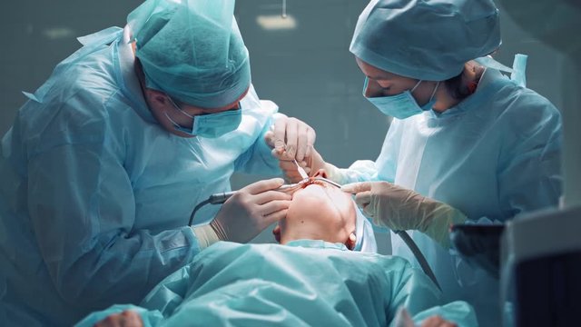 Dentists during surgery for implant placement. Dental clinic concept.
