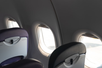 Airplane seats in the cabin economy class and the windows of the airplane. A view of porthole...