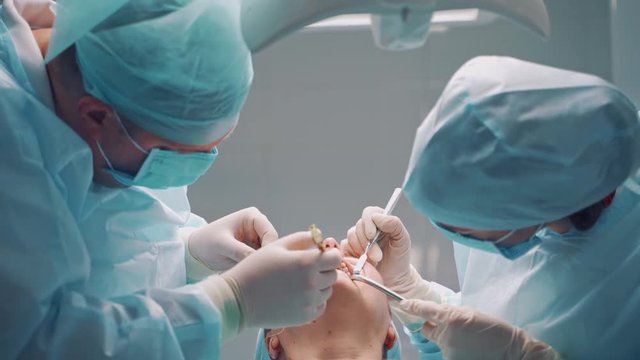 Dental implant surgery. Dentists during surgery for implant placement