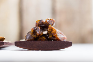 dried fruits and spices on wooden tray, white table