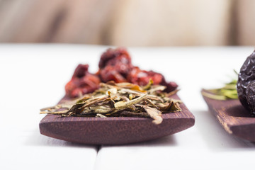 dried fruits and spices on wooden tray, white table
