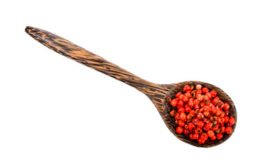 dried pink peppers seed in wood spoon on white background