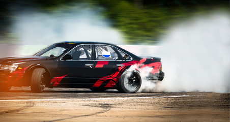Sport car wheel drifting. Blurred of image diffusion race drift car with lots of smoke from burning tires on speed track. Sport concept,Drifting car concep - obrazy, fototapety, plakaty