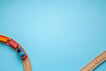 Children's railway with wooden rails on a blue background, top view. Copy space for text.