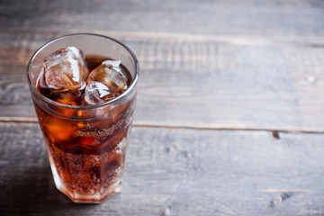 Refreshing cold cherry cola on the wooden background. Selective focus.