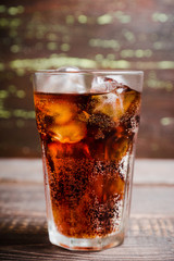 Refreshing cold cherry cola on the wooden background. Selective focus.