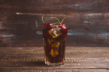 Refreshing cold cherry cola on the wooden background. Selective focus.