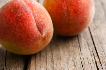 two peach fruits on old weathered wooden table background