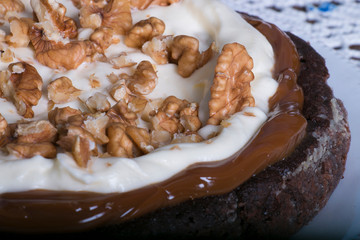 Plano detalle de un delicioso Brownie casero con nueces, crema y dulce de leche 