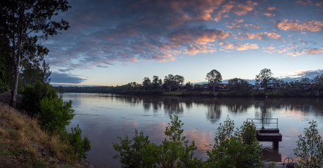 Obraz premium River Sunrise with Dramatic Sky and Reflections