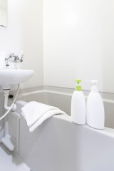Fototapeta na wymiar Bottles of shampoo and bath soap placed in the bathtub in the white bath