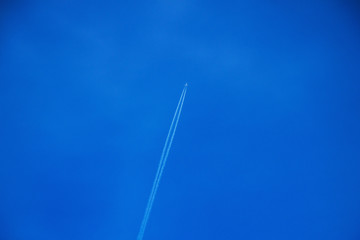 white trace of the plane in the clear blue sky