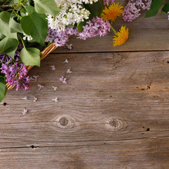 The decor of flowers on the background of vintage wooden planks. Vintage background with flowers of dandelion and lilac and a place under the text. Flat lay. Vintage.