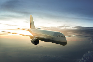 Fototapeta na wymiar Flugzeug bei Sonnenaufgang über den Wolken