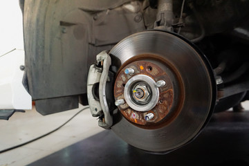 Car brake repairing in garage.Close up. Disc brake of the vehicle for repair, in process of new tire replacement.