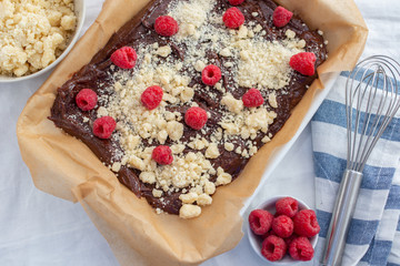 Closeup of chocolate cake with raspberry and streusel on a table