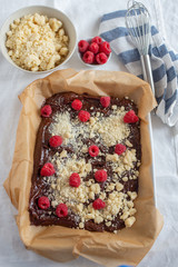 Closeup of chocolate cake with raspberry and streusel on a table