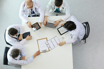 Medical team sitting and discussing at table, top view