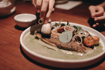 Plate with tasty cooked seabass fish and vegetables on table 