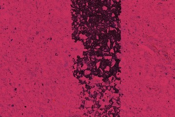 Toned asphalt surface with paint on it close up. Abstract background