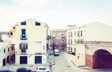 Obraz premium View of old street, facades of ancient buildings in seafront of Ortygia (Ortigia) Island, Syracuse (Siracusa), Sicily, Italy.