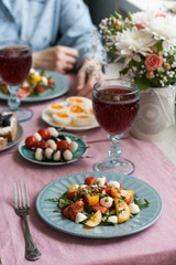 A gourmet lunch for two: salad, canapes, boiled eggs and wine.