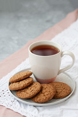 A tasty snack: a cup of tea and a plate of cookies.