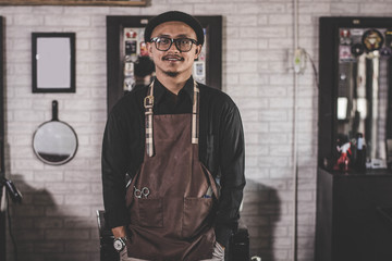 Barber man hairstylist  posing and standing at barbershop salon