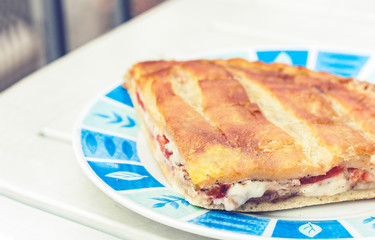 Fried calzone pizza with ham, mozzarella, tomatoes from bakery shop of Catania, Sicily, Italy.