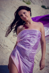 portrait of a young girl in purple and pink cloth in the desert