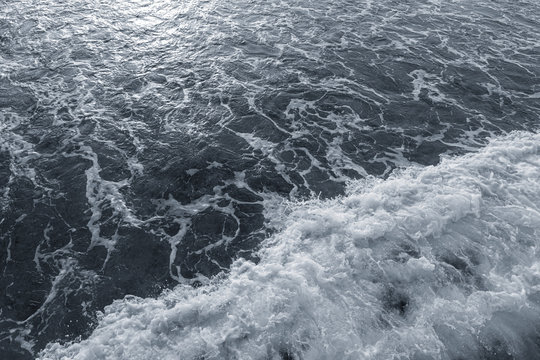 Dark water of stormy sea and white foam. Horizontal color photography.