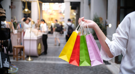 Asian girls holding sale shopping bags. consumerism lifestyle concept in the shopping mall.