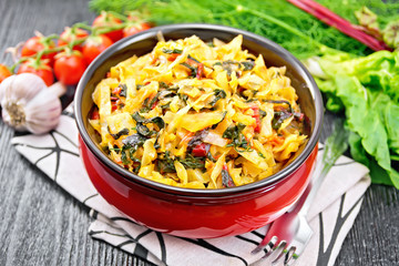 Cabbage stew with chard in bowl on dark board