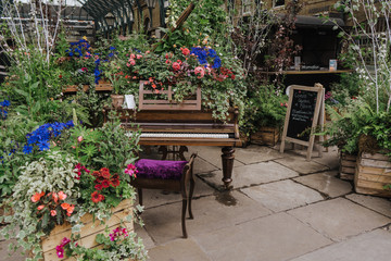 Fototapeta na wymiar Beautiful piano decorated with flowers at Covent Garden, London. Space for text
