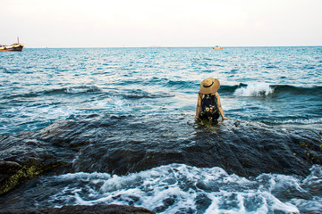 Lonely girl looking at the calm sea with sunset background, Asian girl relaxing on sea shore, Holiday vacation travelling in Thailand, Samed island, Thailand