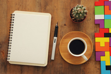 Open notebook with empty pages over wooden old office desk table. Top view, flat lay