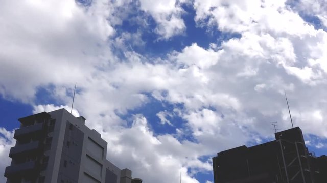 タイムラプス　郊外マンションに流れる雲