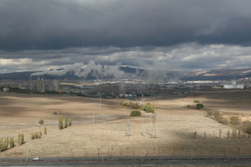 Obraz premium Air pollution created by the smoke coming from the chimney of the cement factory in Turkey's capital city Ankara, cities, mountains and clouds.