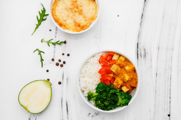 Rice with vegetables in a plate on a white background. Top view. Free space for your text