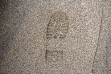 Imprint of the shoe on mud with copy space, Footprint in the dirt, Foot step on sand, background texture. Top view.