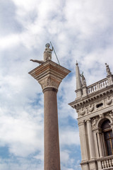 Fototapeta na wymiar Italy, Venice. St. Mark's Square. The capital of the column of Saint Theodore and part of the facade of the Cathedral of Saint Mark.