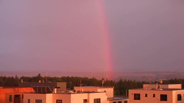Suburban cityscape with a rainbow during sunset