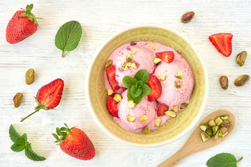 Strawberry ice cream , frozen yogurt with pistachio and mint leaves. Top view	