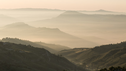 Sunrise on hills with haze in sicily, italy