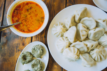Table served with georgian dishes including hinkali, pkhali and soup.