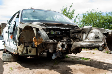 Obraz na płótnie Canvas disassembled silver car without engine and wheels on the street