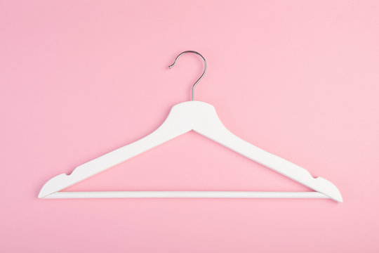 One white wooden hanger isolated on pink background. Copy space for text. Flat lay.