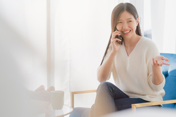 Fototapeta premium beautiful asian woman communication with friend in happiness mood morning weekend home background